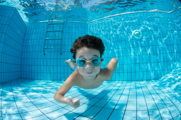 Underwater Young Boy Fun in the Swimming Pool with Goggles Underwater Young Boy Fun in the Swimming Pool with Goggles underwater diving photos stock pictures, royalty-free photos & images