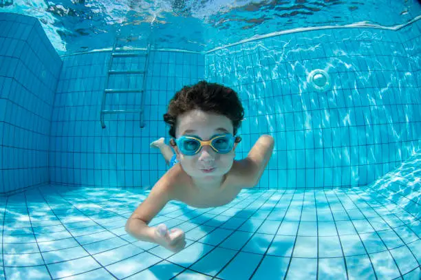 Photo of Underwater Young Boy Fun in the Swimming Pool with Goggles