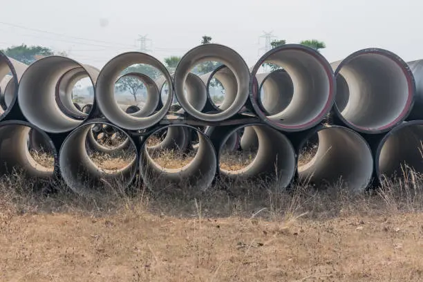 close view of ductile iron pipe kept on open field of store yard.