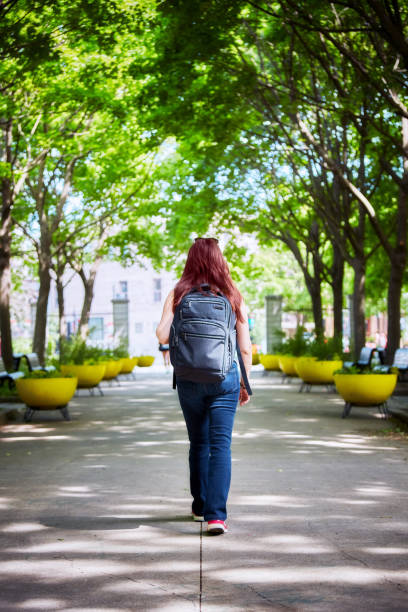 istock Female with backpack walking in the park 1147612283