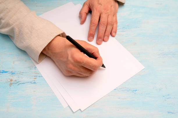 istock A pen in a man's hand. White sheet of paper. 1147613309