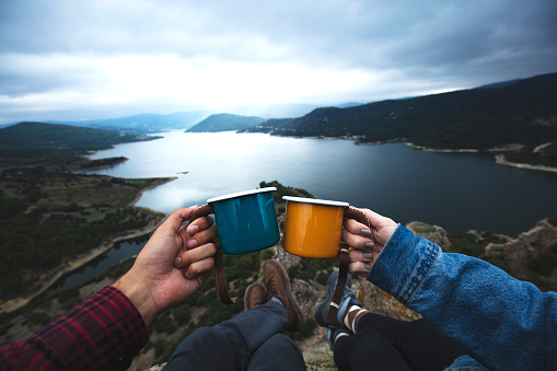 Two climbers in nature drinking coffee in enamel mugs