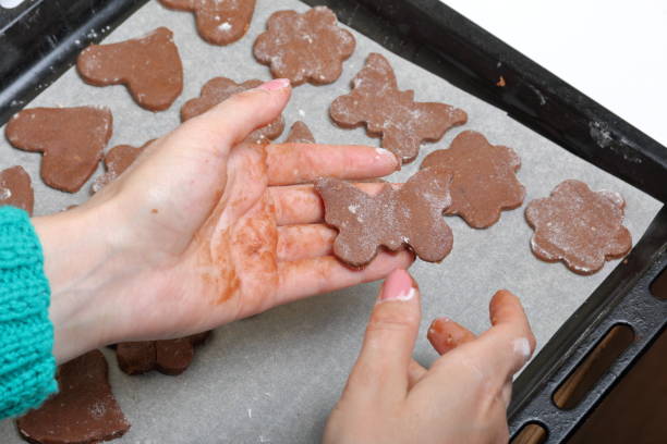 istock A woman is holding a gingerbread blank. The working surface is in flour, the tools lie next to it. Cooking gingerbread. 1147613582