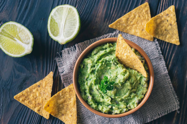 bowl of guacamole with tortilla chips - wood chip fotos imagens e fotografias de stock