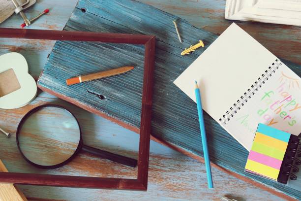 istock Tools, frame, notebook, congratulation on a wooden table, top view, father's day 1147615056