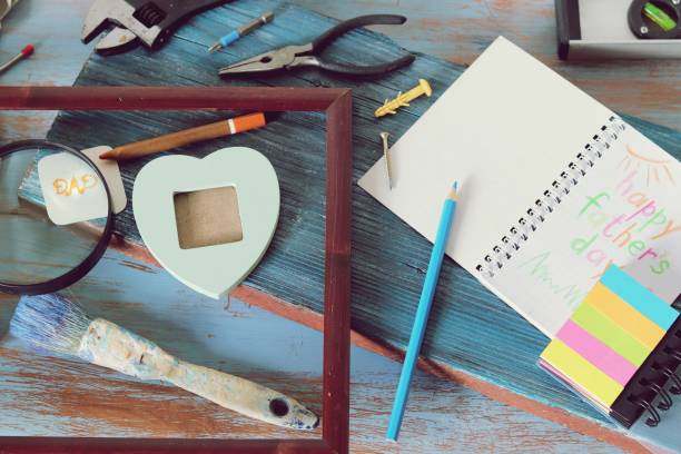 istock Tools, frame, notebook, congratulation on a wooden table, top view, father's day 1147615070