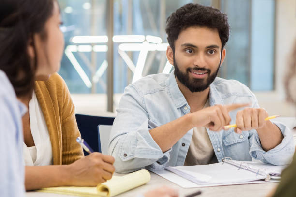istock Mid adult student talks with friends during study session 1147615973