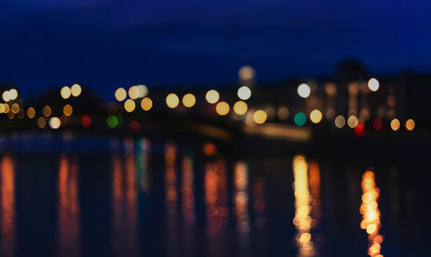 istock Abstract background of blurred city lights with bokeh effect reflected on water. 1147618636