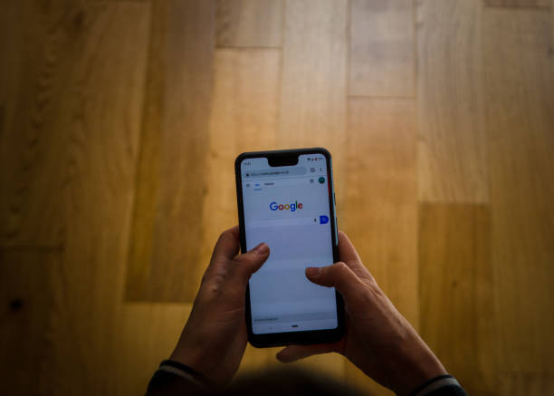 a woman using a google pixel 3 xl  at home . - google imagens e fotografias de stock