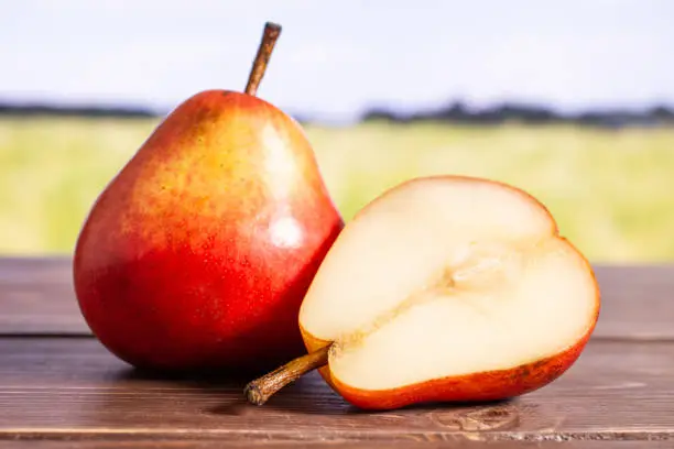 Photo of Fresh red pear with field behind