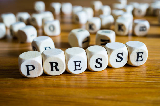 istock Press with wooden cube written in german 1147622900