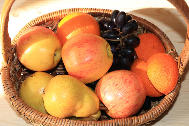 istock Juicy black grapes and apples in a basket on the table. 1147624108