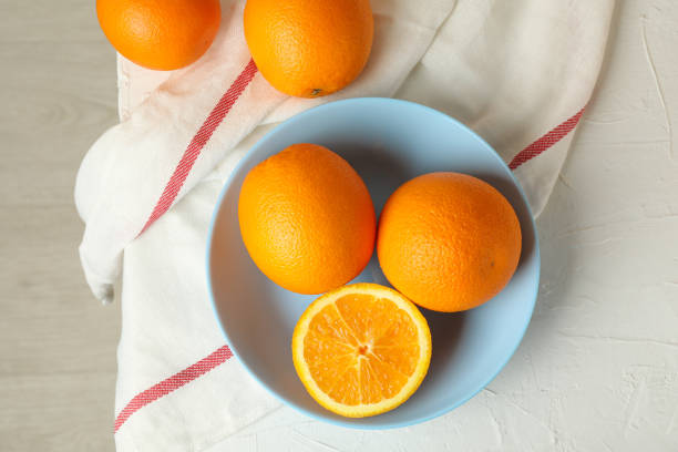 istock Plate with oranges and kitchen towel on white background, top view 1147628099