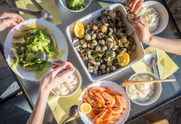 istock People Enjoying a Meal with Fresh Seafood and Vegetables. 1147628508