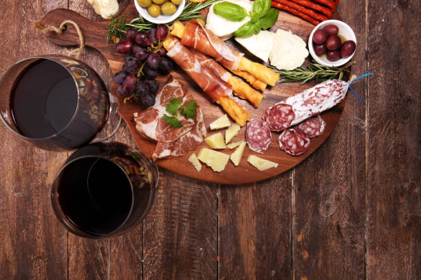 istock antipasto various appetizer. Cutting board with prosciutto, salami, cheese, bread and olives on dark wooden background 1147628804