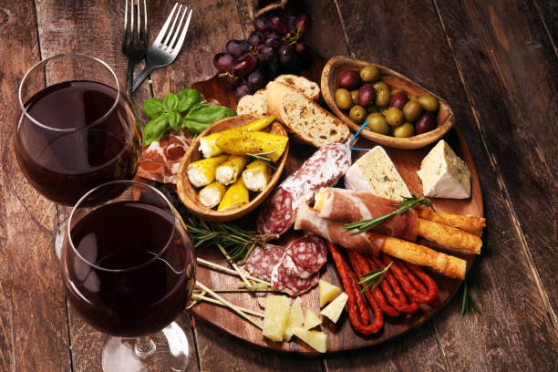 istock antipasto various appetizer. Cutting board with prosciutto, salami, cheese, bread and olives on dark wooden background 1147628951