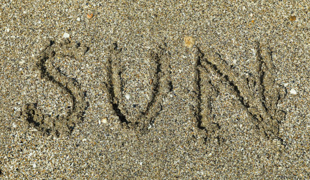 istock Sea sand with inscription sun, top view. Summer backdrop 1147631380