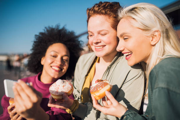 istock Girls taking a selfie when eating donuts 1147631501