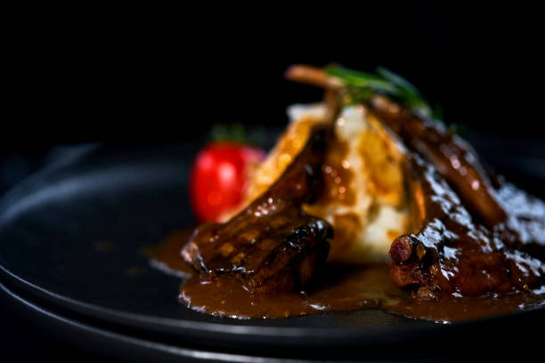 istock rack of lamb on a black plate with garnish 1147632016