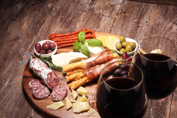 istock antipasto various appetizer. Cutting board with prosciutto, salami, cheese, bread and olives on dark wooden background 1147632021