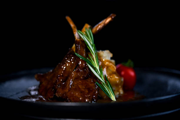 istock rack of lamb on a black plate with garnish 1147632054