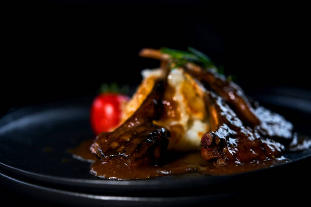istock rack of lamb on a black plate with garnish 1147632083