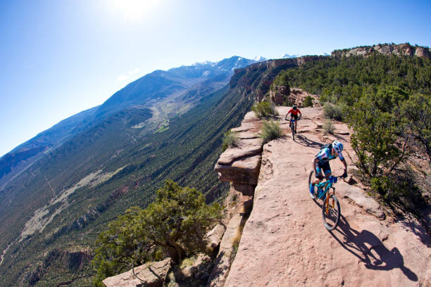 Moab Rocks Mountain Bike Race Geoff Kabush leads Chris Baddick along the edge of Porcupine Rim during the Moab Rocks mountain bike race near Moab, Utah, USA on April 14, 2018. Moab Rocks is a three-day cross-country mountain bike stage race. (John Gibson Photo/Gibson Pictures) la sal mountains stock pictures, royalty-free photos & images