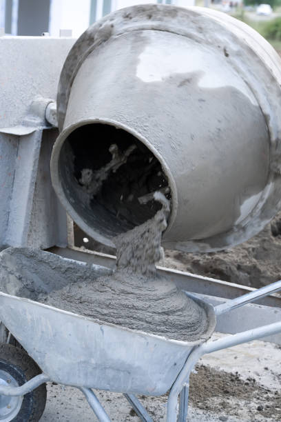 Construction site work with concrete mixer and wheelbarrows