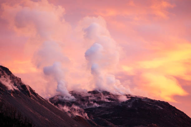Beautiful sunset colors in the sky over the active volcano Chaitén with steam erupting from fumaroles photographed from the main campground in Pumalin Park
