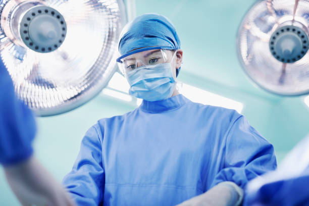cirurgião que executa a operação no quarto de funcionamento - nurse reaching women doctor - fotografias e filmes do acervo