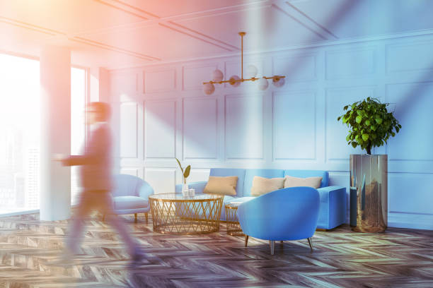 istock Man walking in white living room with sofa 1147637155