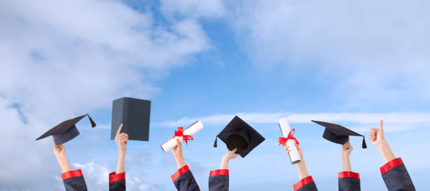istock hands raised and hats and diplomas 1147637290