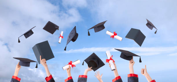 istock hands raised and hats and diplomas 1147637314