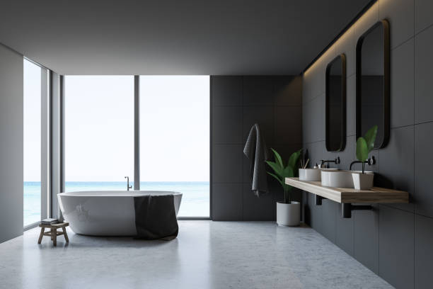 istock Gray tile bathroom interior, tub and sinks 1147638000