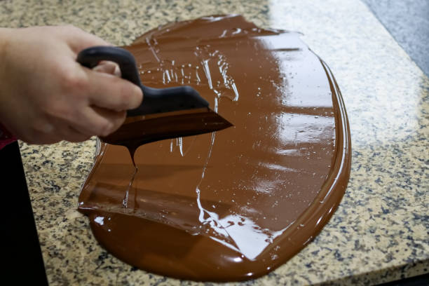 istock Chocolatier stirs the tempered chocolate on a granite table in order to cool 1147640428