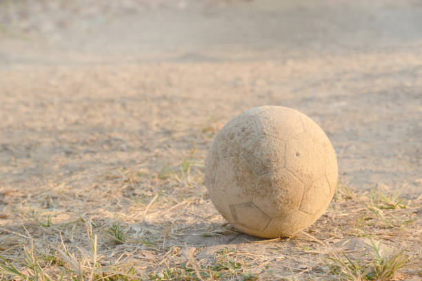 Old football on ground. Selective focus.
