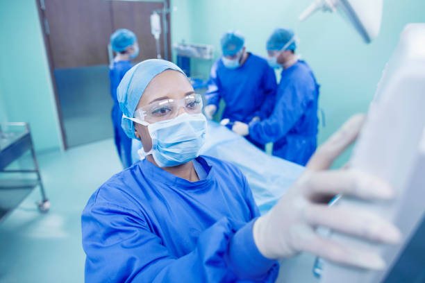lekarz regulujący światło na sali operacyjnej - doctor preparation surgery surgical glove zdjęcia i obrazy z banku zdjęć