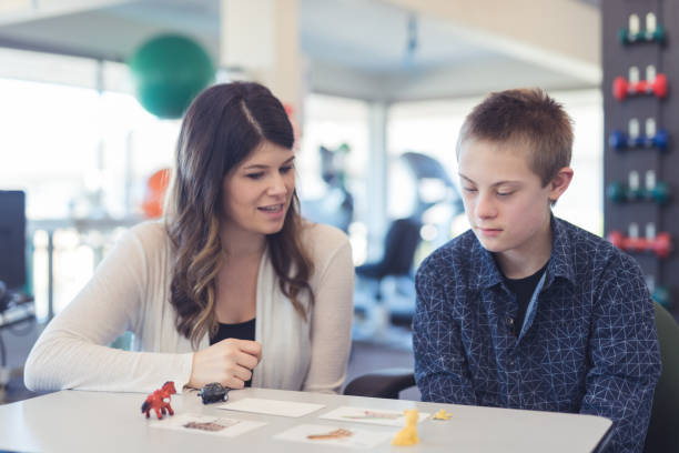 istock Speech therapist works with a young boy 1147656570