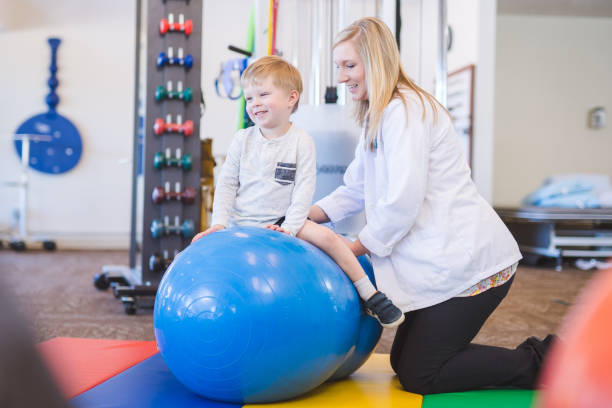 istock Physical therapist working with a young boy in the clinic 1147664067