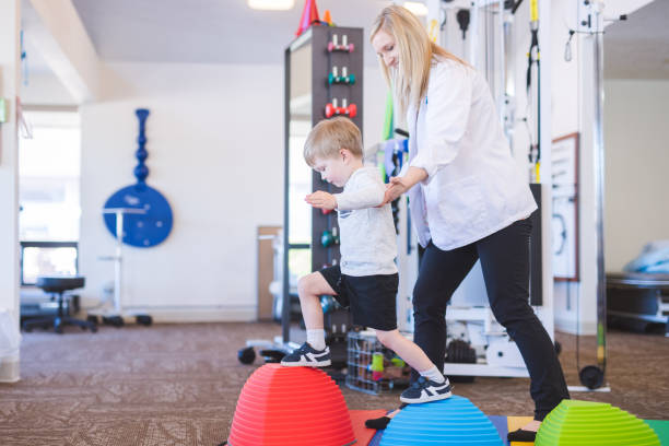 istock Young boy doing a fun exercise with a physical therapist at a clinic 1147664071