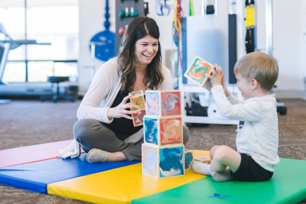 istock Young boy doing a fun building exercise with blocks in a physiotherapy clinic 1147664080