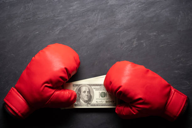 boxing gloves tiene la banconota da banco in dollari su sfondo cemento nero. - cash box immagine foto e immagini stock