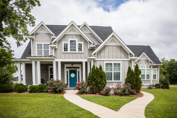 Single Family New Construction Home in Suburb Neighborhood in the South. This is a single family home that is new construction cottage style house with hardy board and a partial metal roof. It is grey with a teal door and there is great curb appeal. The house has a double front entrance and it is on a large lot. curb photos stock pictures, royalty-free photos & images
