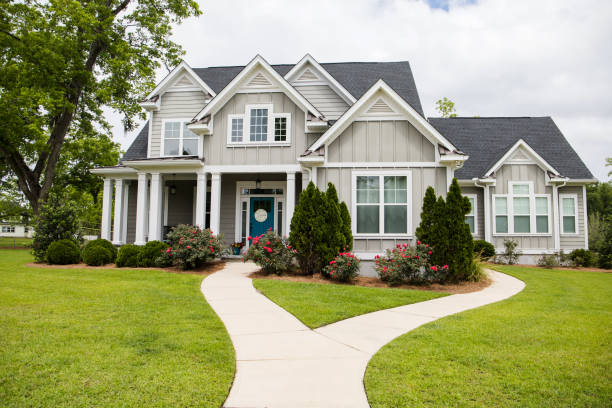 Single Family New Construction Home in Suburb Neighborhood in the South This is a single family home that is new construction cottage style house with hardy board and a partial metal roof. It is grey with a teal door and there is great curb appeal. The house has a double front entrance and it is on a large lot. luxury homes tranquil suburbs stock pictures, royalty-free photos & images