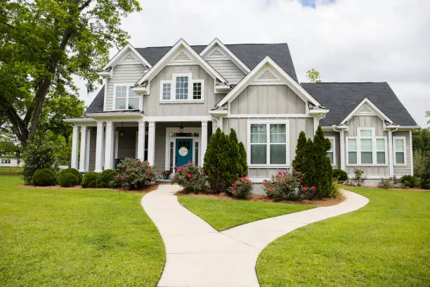 This is a single family home that is new construction cottage style house with hardy board and a partial metal roof. It is grey with a teal door and there is great curb appeal. The house has a double front entrance and it is on a large lot.