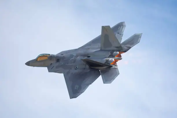 Very close tail  view of a F-22 Raptor against clouds, with afterburners on