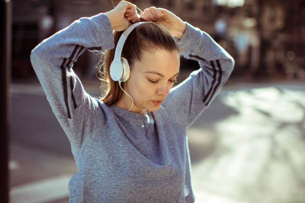 Getting Ready Close up of a woman tying her hair before jogging woman tying hair in ponytail getting ready for exercising stock pictures, royalty-free photos & images