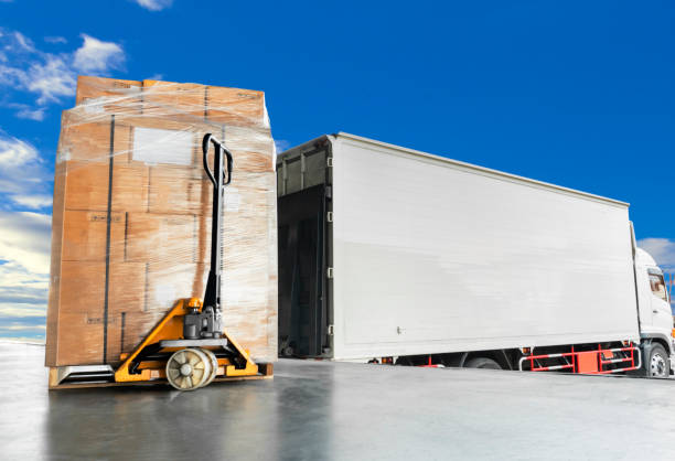 Freight transportation and warehouse Logistic Truck docking at warehouse and hand pallet jack with stacked cardboard boxes on pallet bkk stock pictures, royalty-free photos & images