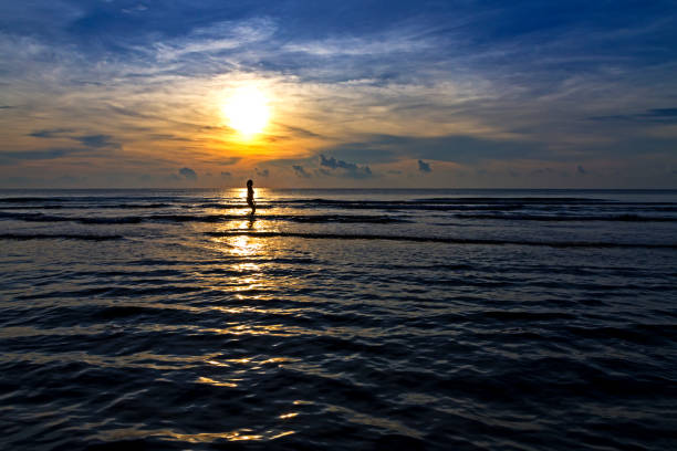 istock Woman put bikini twilight on beach at Ban Krut Beach 1147684327