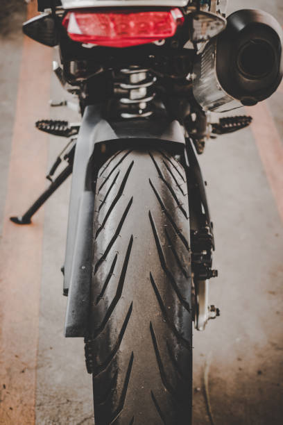 istock motorcycle rear wheel with exhaust pipes. 1147685188